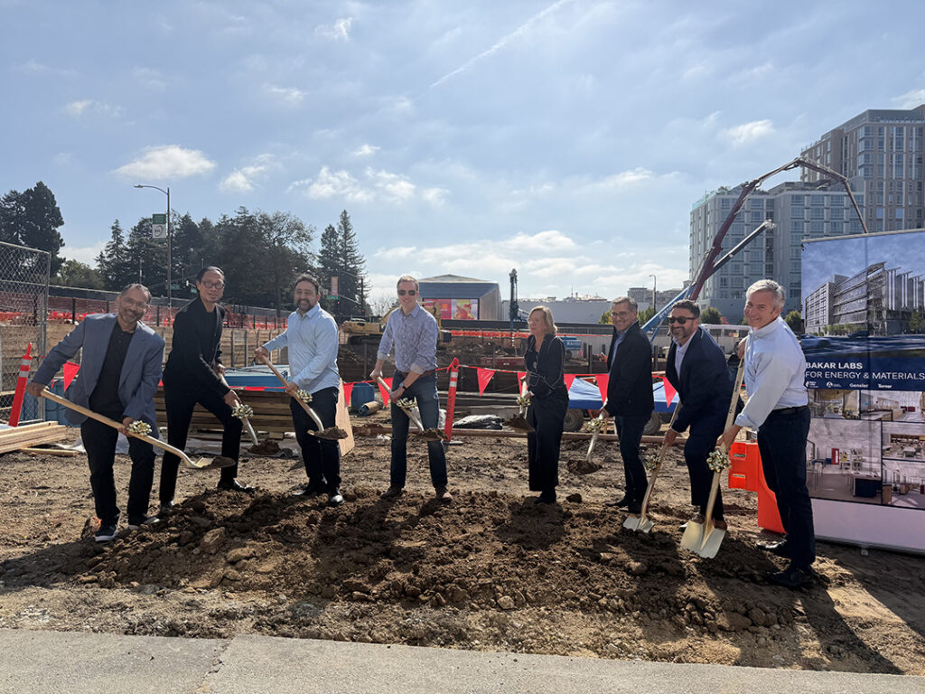A group of people pose with shovels in a construction site